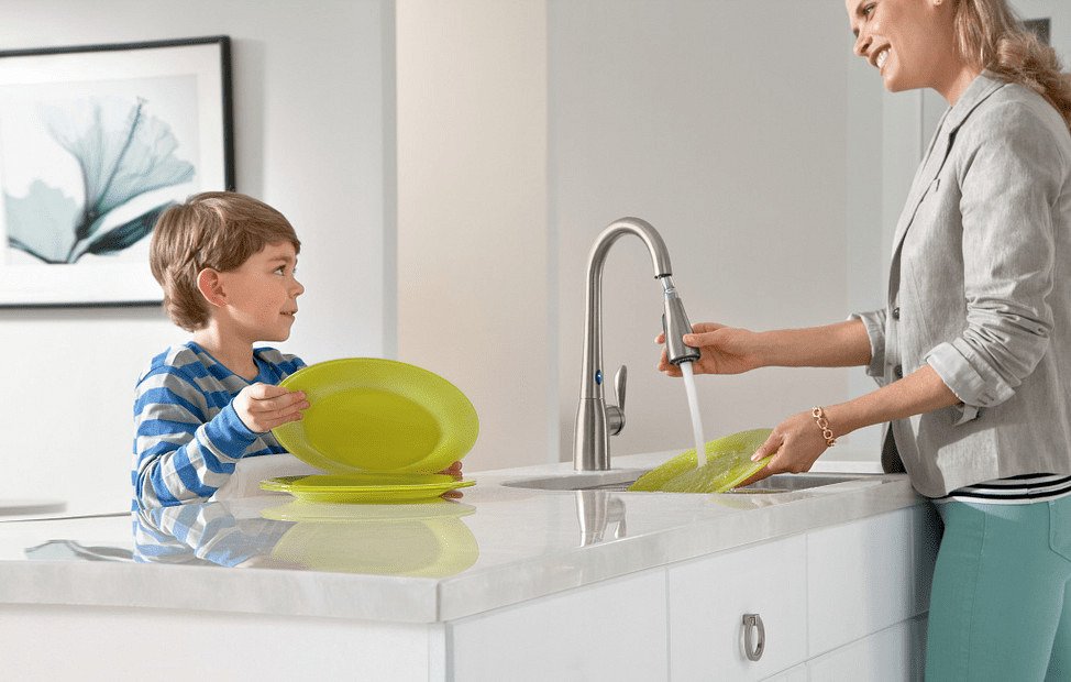 Mother and Child Cleaning Dish in Kitchen Sink