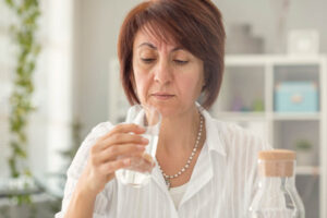 Person looking closely at a glass of water