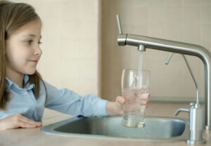 Person drinking water from the tap